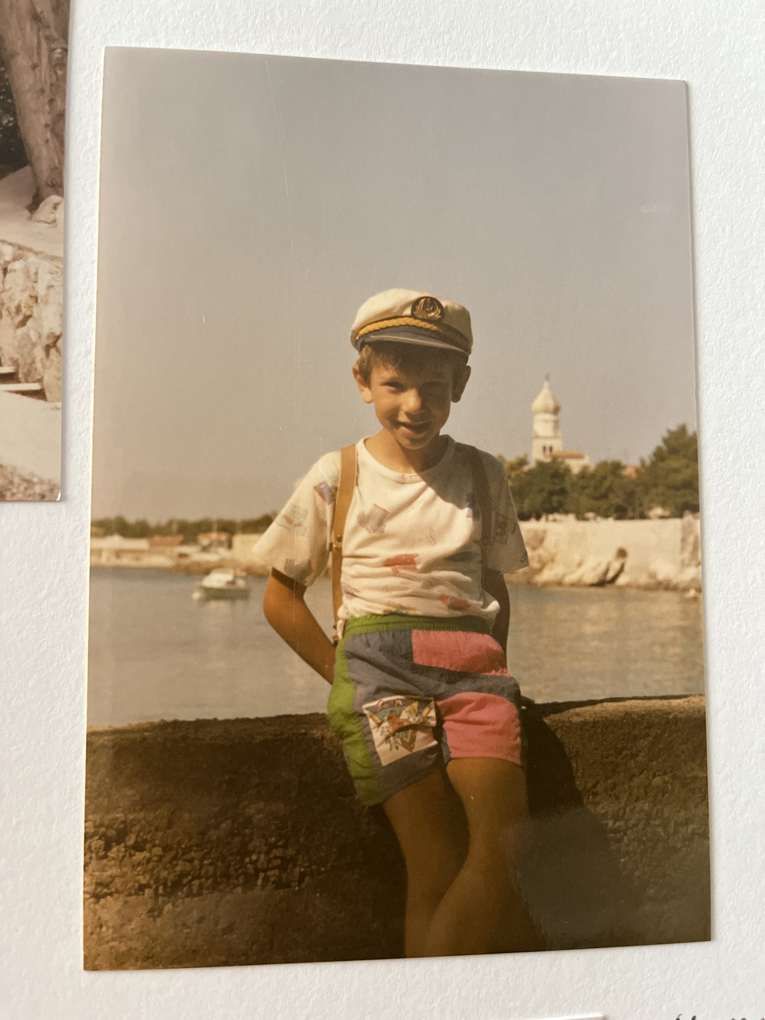 Michael da bambino con il berretto da capitano al mare